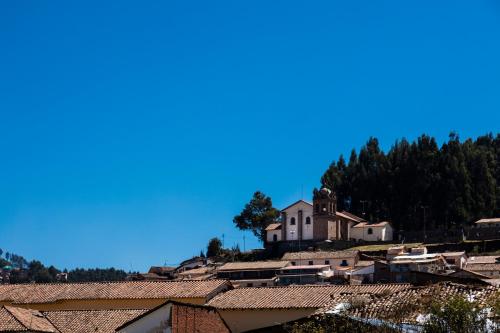 a view of a village with a church on a hill at Hostal & Apartments El Triunfo in Cusco
