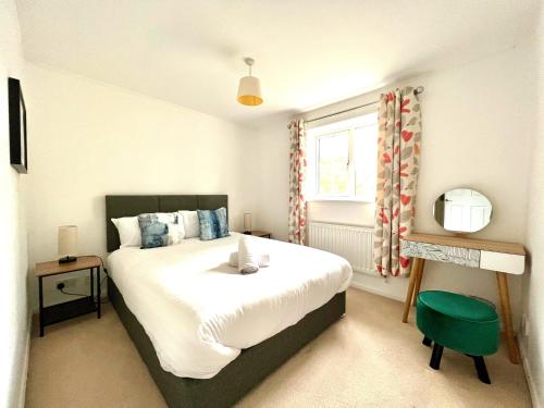 a bedroom with a large bed and a window at Comfortable 3 bedroomed house in Bicester in Bicester