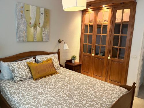 1 dormitorio con 1 cama y armario de madera en Tenerife apartamento Sun Beach & Relax, en Puertito de Güímar