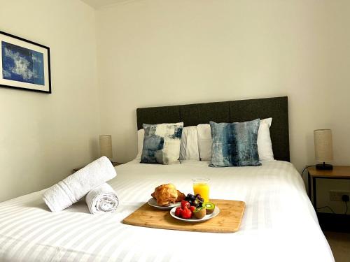 a tray with a plate of food on a bed at Comfortable 3 bedroomed house in Bicester in Bicester
