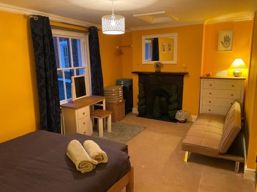 um quarto com paredes amarelas, uma cama e uma lareira em The Old Court House & Jail em Menai Bridge