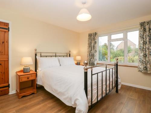 a bedroom with a bed and a window at Lanes End in Sherborne