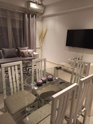 un soggiorno con tavolo e sedie in vetro di Tulipe appartement a Orano
