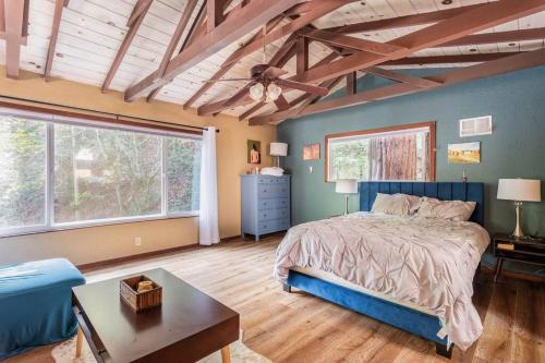 a bedroom with a blue bed and a table at Tranquil creek mountain house in Los Gatos