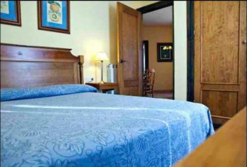 a bedroom with a blue bed with a wooden headboard at Sierra Nevada Plaza Andalucia localización fantástica in Sierra Nevada