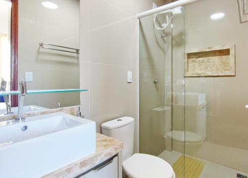 a bathroom with a toilet and a glass shower at House Aconchegante Ponta Negra in Natal