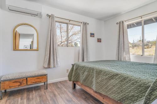a bedroom with a bed and a mirror and a window at Shooting Star Lodge in Joshua Tree