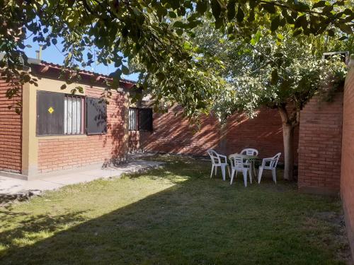 a patio with a table and chairs under a tree at Casa Santa Elena in Malargüe