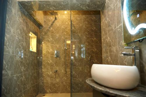 uma casa de banho com um lavatório e um chuveiro em Mayfair Hotel Wuse2 Abuja em Abuja
