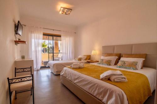 1 Schlafzimmer mit 2 Betten und einem Fenster in der Unterkunft Amazing Apartment With Pool View in Vilamoura