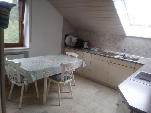 a kitchen with a table and chairs and a sink at Ferienwohnung Soherr in Erolzheim