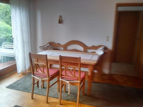 a dining room table with two chairs and a bed at Ferienwohnung Soherr in Erolzheim