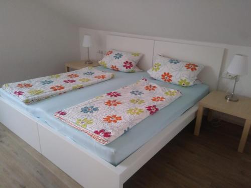 un letto bianco con due cuscini sopra di Ferienwohnung Soherr a Erolzheim