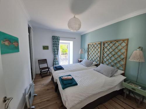 a bedroom with two beds and a window at Casinha de santo Antonio in Villa Nogueira