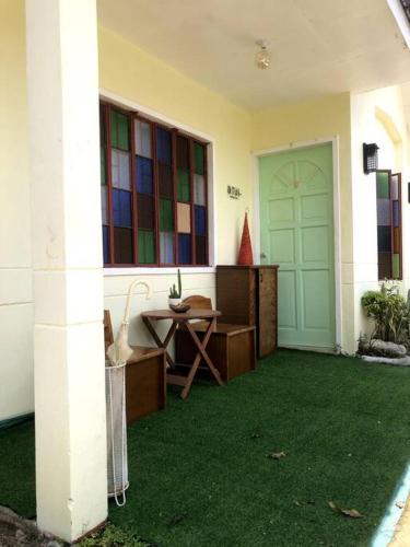 Makilala的住宿－1 BR Staycation near Kidapawan City，一间设有门、桌子和绿草的房间