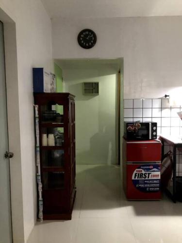 Makilala的住宿－1 BR Staycation near Kidapawan City，客厅配有墙上的时钟和橱柜