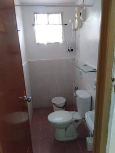 un piccolo bagno con servizi igienici e lavandino di 1 BR Staycation near Kidapawan City a Makilala