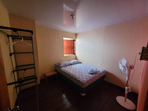 um pequeno quarto com uma cama e uma escada em Casa Vero 2 em Cahuita