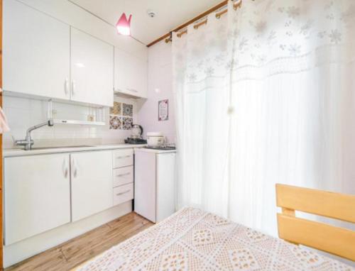 a small kitchen with white cabinets and a sink at Gilson Story Pension in Pyeongchang 