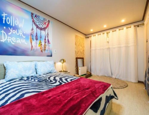 a bedroom with a bed with a large painting on the wall at Gilson Story Pension in Pyeongchang 