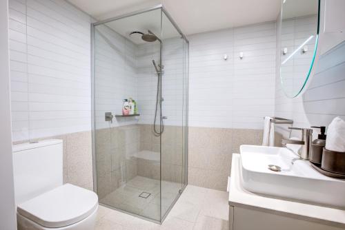 a bathroom with a shower and a toilet and a sink at The Hamptons - Lux 2 Bed 2 Bath, Pool - Central Location in Canberra