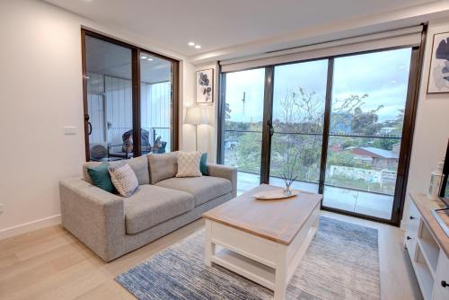a living room with a couch and a table at The Hamptons - Lux 2 Bed 2 Bath, Pool - Central Location in Canberra