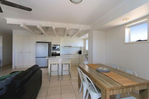a kitchen and living room with a table and a couch at Sandcastles 6 in Bargara