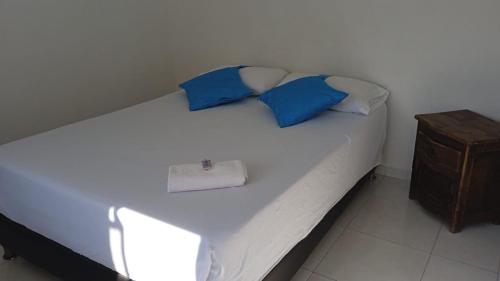 a bed with blue and white pillows on it at HOTEL ANAPOIMA PLAZA IN in Anapoima