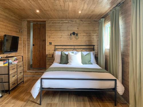 Boyton的住宿－Uk41510 - The Cabin，卧室配有一张木墙内的大床