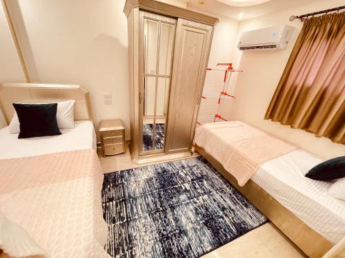 a room with two beds and a window at El mansour hotel apartmen 84 in Mansoura
