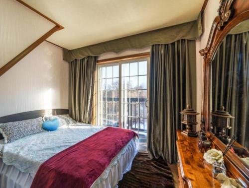 a bedroom with a large bed and a large window at Gilson Story Pension in Pyeongchang 