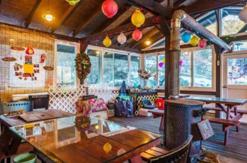 a room with a table and chairs and windows at Gilson Story Pension in Pyeongchang 