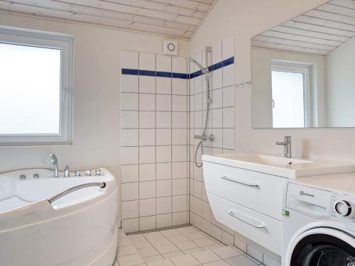 uma casa de banho branca com um lavatório e uma máquina de lavar roupa em Holiday home Nykøbing Sj XL em Nyrup