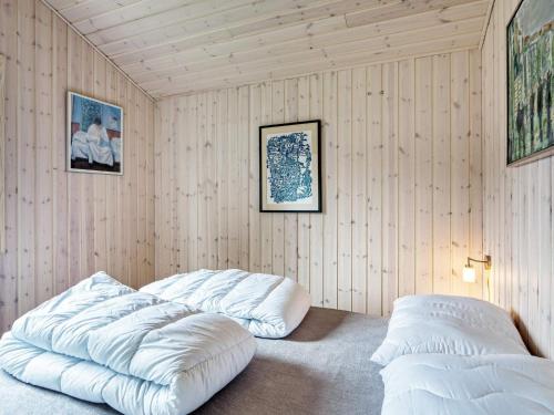 Duas grandes almofadas brancas num quarto com paredes de madeira em Holiday home Nykøbing Sj XL em Nyrup