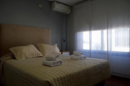 1 dormitorio con 1 cama con toallas en La Infinita en Mendoza