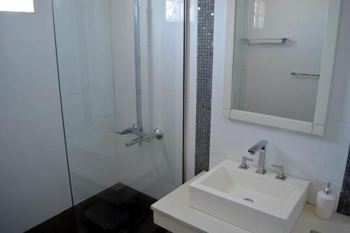 y baño blanco con lavabo y ducha. en La Infinita en Mendoza