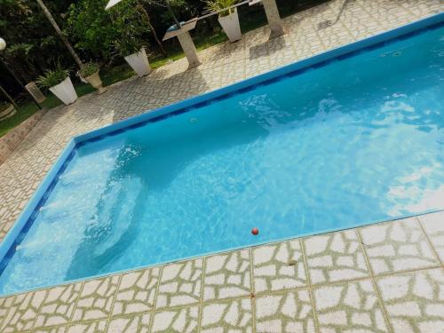 a swimming pool with blue water in a yard at Chácara de Temporada - Mairiporã in Mairiporã