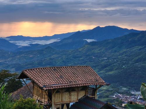 a view of a mountain range with a building at Ecohotel Soplo del Tambo in Cocorná