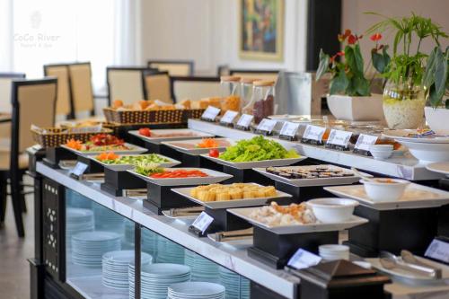 a buffet line with many different types of food at Hoi An Coco River Resort & Spa in Hoi An