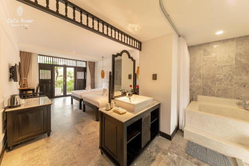 a bathroom with two sinks and a tub and a shower at Hoi An Coco River Resort & Spa in Hoi An