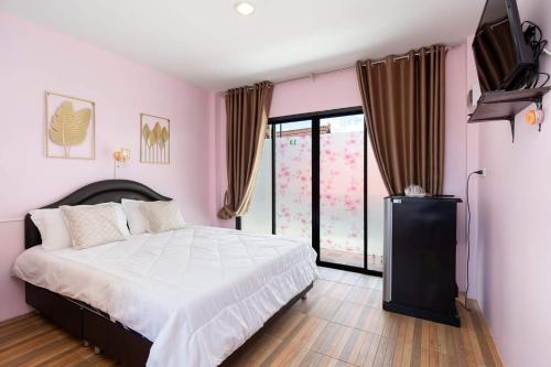 a pink bedroom with a bed and a tv at Brown Home Sattahip @ 19 in Sattahip