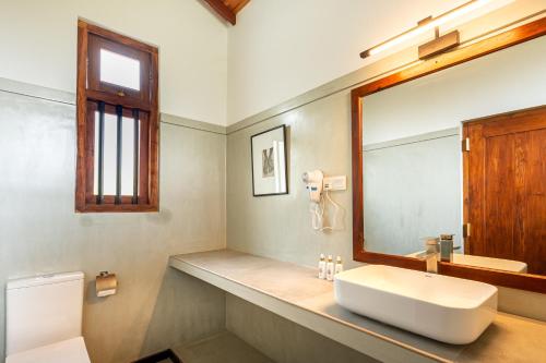 a bathroom with a sink and a mirror at Serenity Boutique - Unawatuna in Unawatuna