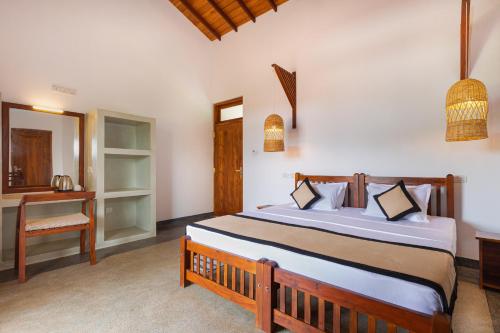 a bedroom with a large bed with a desk and a mirror at Serenity Boutique - Unawatuna in Unawatuna