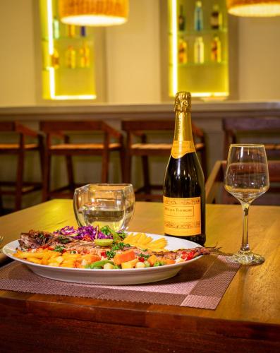 a plate of food and a bottle of wine on a table at Serenity Boutique - Unawatuna in Unawatuna