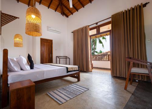 a bedroom with a bed and a large window at Serenity Boutique - Unawatuna in Unawatuna