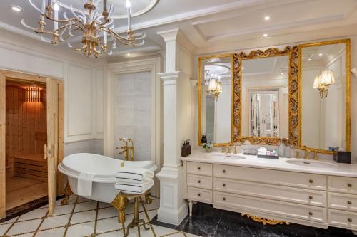 a bathroom with a tub and a large mirror at Melia Vinpearl Quang Binh in Dong Hoi