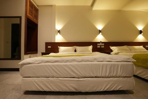 two beds in a bedroom with lights on the wall at Lemuju B&B Hotel in Daxi