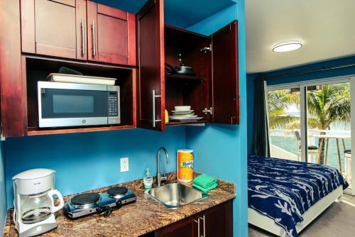 a kitchen with a sink and a microwave and a bed at Cozy Beach Getaway - Lux Studio next to The Morgan Village in Maho Reef