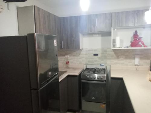 a kitchen with a stove and a refrigerator at Apartamento duplex, con terraza y vista de Chiclayo in Chiclayo