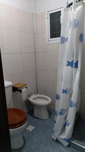 y baño con aseo y cortina de ducha. en Casa Villana en Mendoza